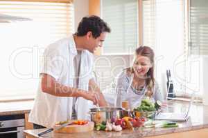 Couple using the internet to look up recipe