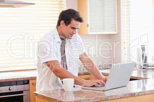 Man working on his laptop in the kitchen