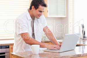 Man working on his notebook in the kitchen
