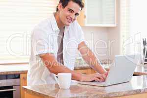 Male working on his laptop in the kitchen