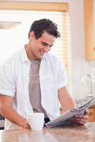 Man reading newspaper in the kitchen