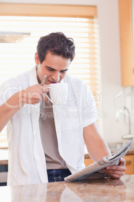 Man having some coffee while reading the newspaper