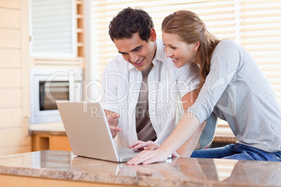 Couple surfing the internet in the kitchen
