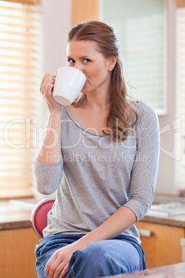 Woman drinking coffee in the kitchen