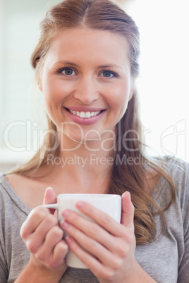 Close up of smiling woman with a cup of coffee