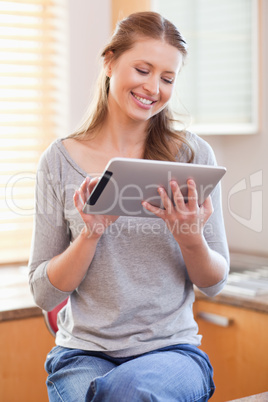 Smiling woman with tablet in the kitchen