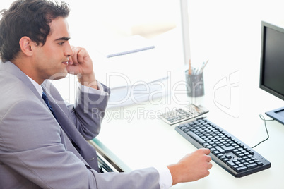 Side view of businessman sitting at his desk