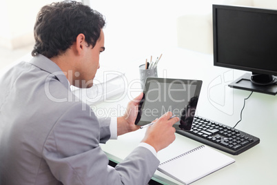 Businessman looking at his tablet in his office