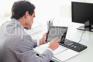 Businessman looking at his tablet in his office