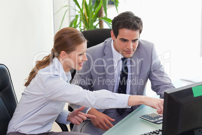 Businesswoman showing her colleague something on the screen