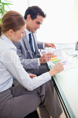 Side view of colleagues analyzing statistics together