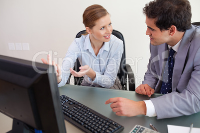 Trading partner sitting behind a desk while talking