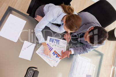 Above view of consultant analyzing statistics with her client