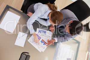 Above view of consultant analyzing statistics with her client