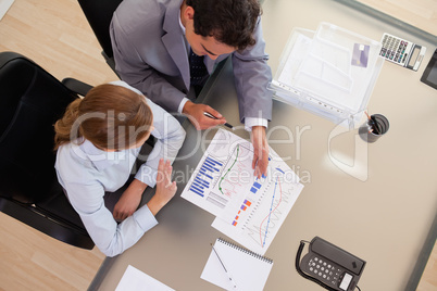 Above view of business people talking about diagram