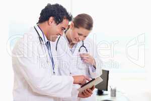 Medical assistants looking at clip board