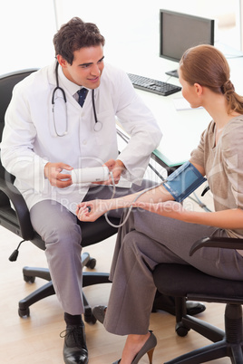 Side view of doctor talking to his patient about blood pressure