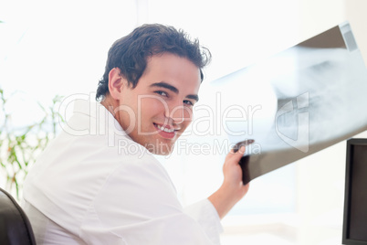 Side view of smiling doctor with x-ray