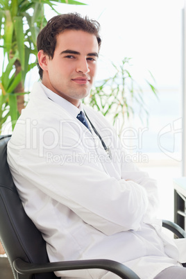 Side view of doctor sitting with arms folded