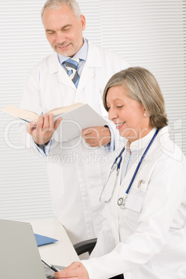 Medical team doctors read book look computer