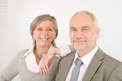 Senior businesspeople lean over shoulder colleague