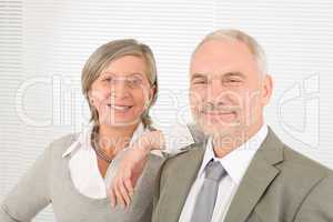Senior businesspeople lean over shoulder colleague