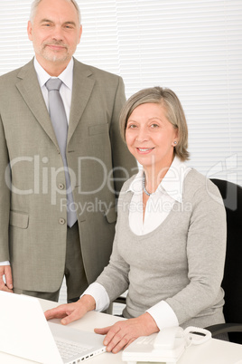 Senior happy businesspeople working on computer