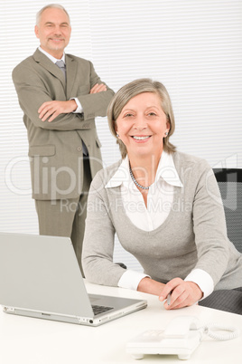 Senior businesspeople in office work on computer