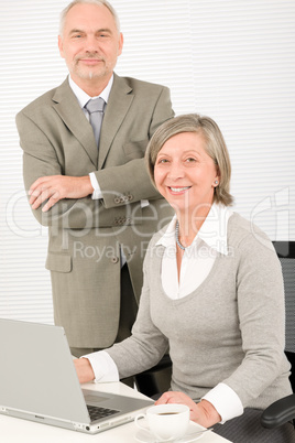 Senior businesspeople in office work on computer