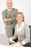 Senior businesspeople in office work on computer