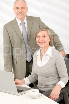 Senior businesspeople in office work on computer