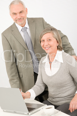 Senior businesspeople in office work on computer