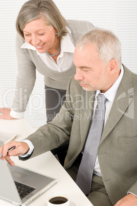 Senior businesspeople in office work on computer