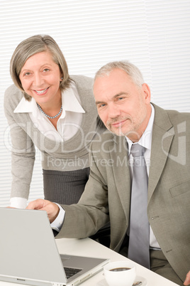 Senior businesspeople in office work on computer