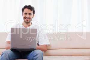 Smiling man using a laptop