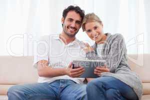 Charming couple using a tablet computer