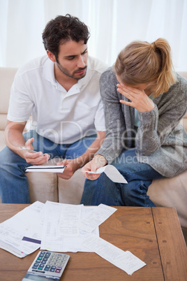 Portrait of a sad couple looking at their bills