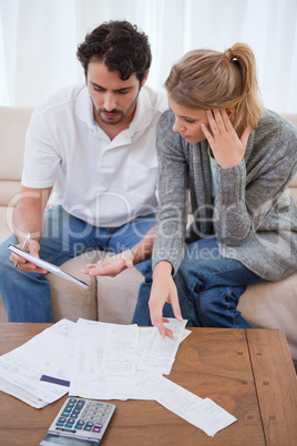 Portrait of a worried couple looking at their bills