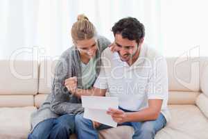 Cheerful couple reading a letter