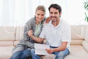 Delighted couple reading a letter