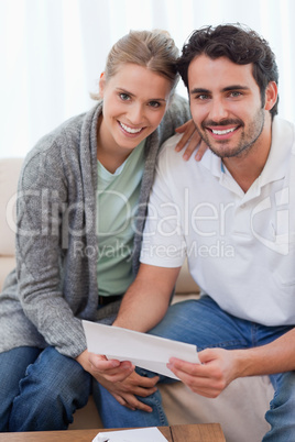 Portrait of a smiling couple reading a letter