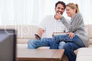 Lovely couple watching TV while eating popcorn