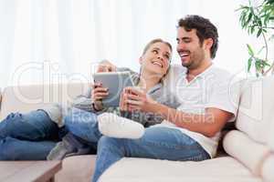 Delighted couple using a tablet computer
