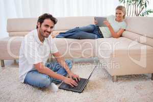 Woman using a tablet computer while her boyfriend is using a not