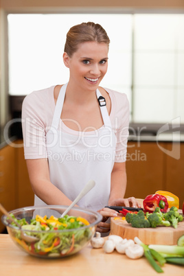 Portrait of a cute woman slicing vegetables