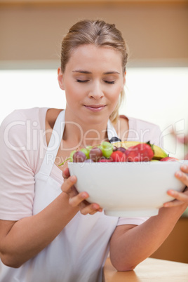 Portrait of a woman smelling a fruit basket