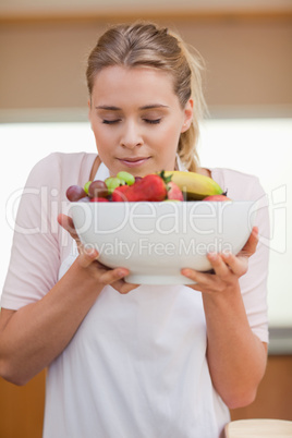 Portrait of a young woman smelling a fruit basket