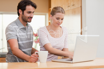 Couple using a laptop while having coffee