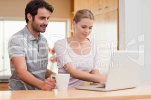 Couple using a laptop while having coffee