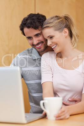 Portrait of a couple using a laptop while having tea